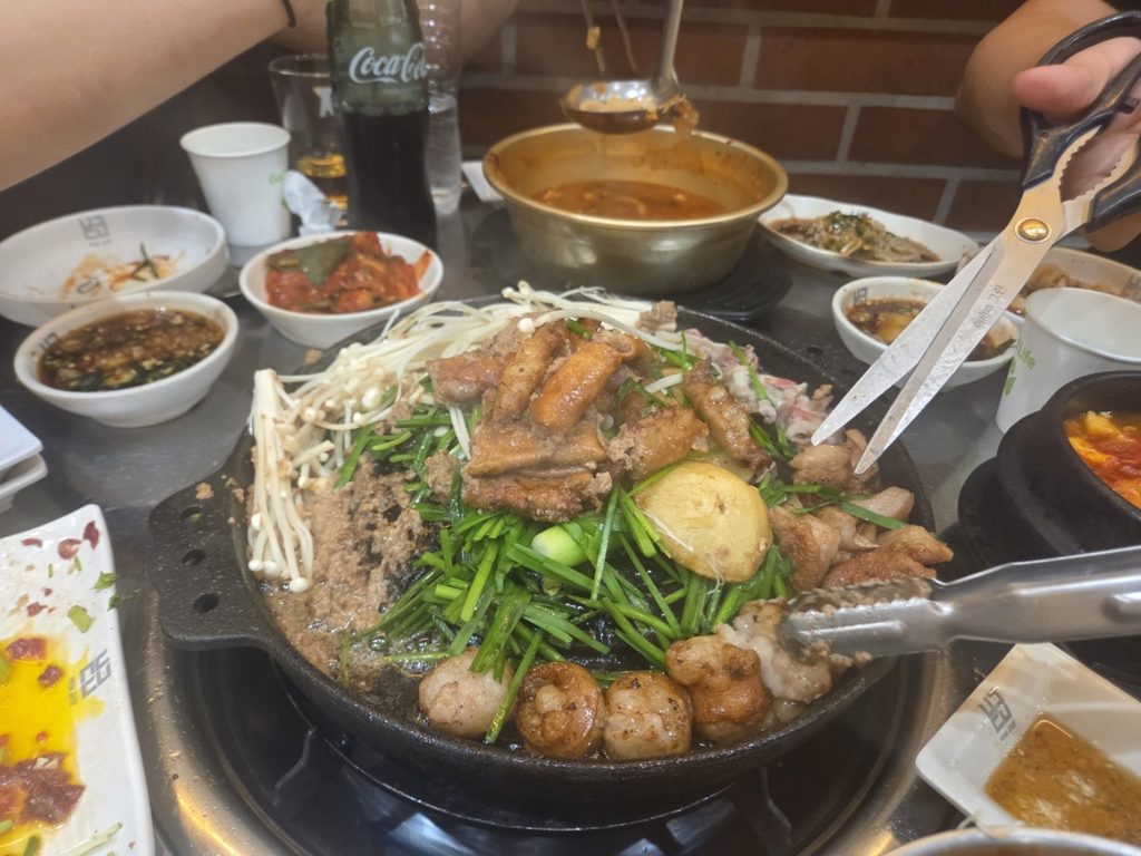 벽돌곱창 대흥점 불판에서 노릇하게 익은 곱창과 대창 부추